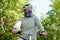 Young cauacasian man in helmet cycling outdoor in forest closing his face with scarf