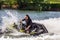 Young Caucaisian woman drives jet ski splashing at sunset by river bank at countryside. Extreme sports and active vacation concept