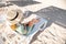 Young caucasian attractive woman in a green dress and a straw hat resting in the early morning on a lounger on a sandy