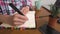 Young Caucasian attractive woman taking notes in her notebook while sitting in the kitchen at the table. Paper notebook