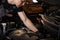 Young caucasian auto mechanic in a car service, checks a car, engine, carburetor