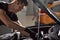 Young caucasian auto mechanic in a car service, checks a car, engine, carburetor