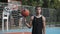 Young Caucasian Basketball Player Wearing Black Singlet Spinning the Ball on his Finger Standing at Street Basketbal