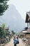 Young Caucasian blonde woman with backpack standing on the central street of Muang Ngoi village, Laos