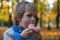 Young caucasian boy 5 years old eating donut outdoors closeup. Childhood.