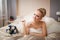 Young Caucasian bride laying on bed at home with bouquet closeup