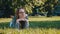 Young caucasian brunette with glasses lying on the grass in the park and thinking. Relaxation in the nature