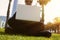 Young caucasian businessman in formal clothes working at sunny day on green grass on laptop.Closeup. Blurred background.