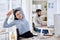 Young caucasian call centre telemarketing agent stretching her arms while working in an office. Female consultant taking