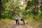 Young caucasian couple of cyclists walk and push their mountain bikes along the forest road in the park. Active sports weekend.