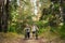 Young caucasian couple of cyclists walk and push their mountain bikes along the forest road in the park. Active sports weekend.