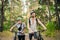 Young caucasian couple of cyclists walk and push their mountain bikes along the forest road in the park. Active sports weekend.