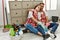 Young caucasian couple relaxing after clean sitting on the floor at home