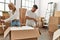 Young caucasian couple smiling happy unboxing cardboard box at new home