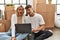 Young caucasian couple surprised using laptop sitting at new home