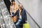 Young caucasian couple together with paper bags in escalator