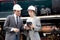 Young caucasian engineer man and woman in suit checking train with tablet in station.