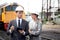 Young caucasian engineer man and woman in suit checking train with tablet in station.