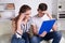 Young Caucasian family having debt problems, not able to pay out their loan. Female in glasses and brunette man studying