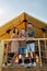 Young Caucasian family of three standing by glamping house