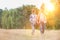 Young Caucasian family walking across field with young girl holding bouquet of flowers, concept organic ecologically friendly fami