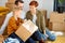 Young caucasian family writing on cardboard boxes for moving day