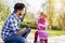 Young caucasian father high fiving with his daughter while teaching her how to ride a bike in a park