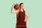 Young caucasian female basketball player against mint colored studio background