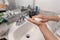 Young Caucasian Female Hands Lathering White Bar Hand Soap for Washing and Personal Hygiene, and Then Rinsing Hand Under Sink Wate