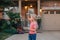 Young Caucasian girl blowing soap bubbles on home front yard. Child having fun outdoors on sunset. Authentic happy childhood magic