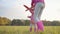 Young caucasian girl helping her little cute sister playing with a pink toy airplane. Pretty blonde child in dotted