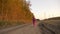 Young caucasian girl running jumping by country road. White blonde long hair girl jumping outdoors.