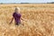 Young caucasian girl running in wheatfield facing away.