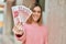 Young caucasian girl smiling happy holding iceland kronur banknotes at the city