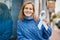 Young caucasian girl smiling happy holding white awareness ribbon at the city