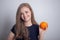 Young caucasian girl woman with orange in hands, healthy lifestyle