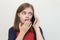 Young caucasian girl woman is talking on the mobile phone, looks scared, worried or sad