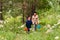 Young Caucasian grandmother and boy walking in the woods in the summer. grandmother holds grandson`s hand