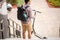 Young caucasian guy holding electric scooter, standing on a dais, planning optimal route in big modern city bypassing traffic jams