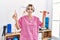 Young caucasian gynecologist woman holding fallopian tube anatomical model and menstrual cup at the clinic