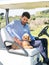 Young Caucasian male in a golf cart with his Goldendoodle puppy on a professional golf course