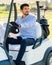 Young Caucasian male in a golf cart with his Goldendoodle puppy on a professional golf course