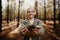 Young caucasian male holding twigs in hand from earthy green forest.