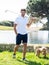 Young Caucasian male playing with his Goldendoodle dog on a professional golf course