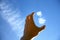 Young Caucasian male`s hand catches small white cloud against clear blue sky