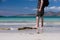 Young caucasian male taking a walk on a white sandy beach with turquoise water on his vacation.