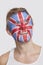 Young Caucasian man with British flag painted on face day dreaming against white background