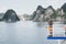 Young Caucasian man with a camera standing on a ferry deck overlooking Halong Bay, Vietnam