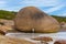 Young caucasian man in front of a huge rock at Lucky Bay, Cape Le Grand National Park near Esperance, Australia