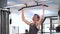 Young caucasian man gym beginner doing pull up exercise in the gym.